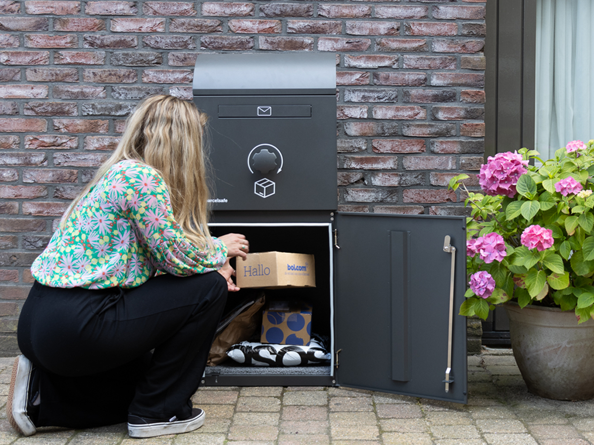 Pakketbezorger levert een pakket af in een Parcelsafe pakketbrievenbus